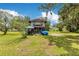 View of backyard featuring a vintage two-story home with a covered porch and spacious lawn at 9329 7Th Ave, Orlando, FL 32824