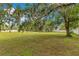 Large grassy backyard with mature tree, offering shade and a tranquil setting at 9329 7Th Ave, Orlando, FL 32824