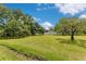 Beautiful, large backyard with green grass and mature trees creating a serene outdoor space at 9329 7Th Ave, Orlando, FL 32824