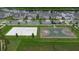 Aerial view of neighborhood with a playground, beach volleyball court, basketball court, and pond nearby at 9941 Introduction Way, Orlando, FL 32832