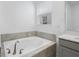 Bright bathroom featuring a soaking tub with tile surround and fixtures at 9941 Introduction Way, Orlando, FL 32832