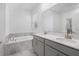 Elegant bathroom with dual vanity sinks, a soaking tub, and large mirror at 9941 Introduction Way, Orlando, FL 32832
