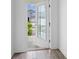 Bright foyer with tile flooring, view of front yard through glass front door at 9941 Introduction Way, Orlando, FL 32832
