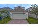 Spacious two car garage with paved driveway, exterior lighting, and neutral color palette at 9941 Introduction Way, Orlando, FL 32832