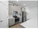 Modern kitchen featuring stainless steel appliances, quartz countertops, and grey cabinets at 9941 Introduction Way, Orlando, FL 32832