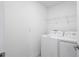 Bright laundry room featuring a white washer and dryer set and wire shelving above at 9941 Introduction Way, Orlando, FL 32832