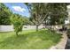 Sprawling backyard with a large shade tree, lush green lawn, and a white fence at 1000 Kewannee Trl, Maitland, FL 32751