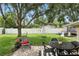 Backyard features an outdoor seating area with a patio, shade tree, and play structures at 1000 Kewannee Trl, Maitland, FL 32751