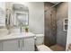 Bathroom featuring a shower with a gray tiled surround, white vanity, and a framed mirror at 1000 Kewannee Trl, Maitland, FL 32751
