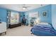 Blue bedroom featuring a ceiling fan, window with shutters, and decorative shelves at 1000 Kewannee Trl, Maitland, FL 32751