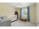Bright bedroom with yellow walls, a ceiling fan, and a crib by the window at 1000 Kewannee Trl, Maitland, FL 32751