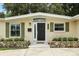 Close-up of the front entrance showcasing stone accents, green shutters and a modern black door with wreath at 1000 Kewannee Trl, Maitland, FL 32751
