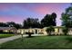 Charming single-story home with a well-manicured lawn, mature trees, and a paved driveway at 1000 Kewannee Trl, Maitland, FL 32751