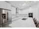 Modern kitchen with glossy white cabinets, stainless steel refrigerator, and a spacious island at 10001 Newington Dr, Orlando, FL 32836