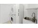 Well-organized laundry room with a stacked washer and dryer and a convenient utility sink at 10001 Newington Dr, Orlando, FL 32836