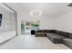 Bright living room featuring a large gray sofa, recessed lighting and sliders to pool area at 10001 Newington Dr, Orlando, FL 32836