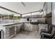 A well-equipped outdoor kitchen features a built-in grill and gray stone accents beneath a partially enclosed patio space at 10001 Newington Dr, Orlando, FL 32836