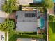 Aerial view of a home with a screened pool, solar panels, a brick driveway, and lush landscaping in a suburban setting at 1008 Soldier Creek Ct, Oviedo, FL 32765