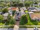 Aerial view of a home with a dark roof and solar panels amid lush greenery and a well-manicured lawn at 1008 Soldier Creek Ct, Oviedo, FL 32765