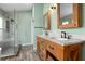 Bathroom with double sink vanity with granite countertop and a tiled glass shower at 1008 Soldier Creek Ct, Oviedo, FL 32765