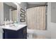 Charming bathroom with blue vanity, framed mirror, and decorative shower curtain at 1008 Soldier Creek Ct, Oviedo, FL 32765