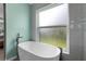 Modern bathroom featuring a white soaking tub next to the window at 1008 Soldier Creek Ct, Oviedo, FL 32765