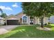 Inviting home featuring arched windows, a two-car garage, and a well-maintained front lawn at 1008 Soldier Creek Ct, Oviedo, FL 32765