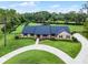 An aerial view of a brick home with a circular driveway and extensive landscaping on a large lot at 104 Amberwood Ct, Longwood, FL 32779