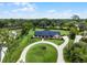 Stunning aerial view of a brick home with a circular driveway on a sprawling, tree-lined lot at 104 Amberwood Ct, Longwood, FL 32779