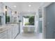 Luxurious bathroom with a soaking tub, double vanity, marble floors, and a view to the outdoor garden at 104 Amberwood Ct, Longwood, FL 32779