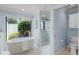 Bright bathroom with a standalone tub beneath a window and a glass enclosed shower with white marble surround at 104 Amberwood Ct, Longwood, FL 32779
