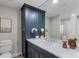 Elegantly appointed bathroom featuring a large vanity with white countertops and a dark blue cabinet at 104 Amberwood Ct, Longwood, FL 32779