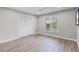 Empty bedroom with wood-look floors, neutral paint, and a large shuttered window and closet at 104 Amberwood Ct, Longwood, FL 32779
