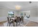 Dining room with a chandelier, wainscoting, and an area rug, open to the living room at 104 Amberwood Ct, Longwood, FL 32779