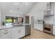 Bright kitchen with stainless steel appliances and an island leading to a dining area and pool view at 104 Amberwood Ct, Longwood, FL 32779