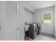 Well lit laundry room with newer model washer and dryer, utility sink, and access to the outside at 104 Amberwood Ct, Longwood, FL 32779
