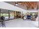 Spacious covered patio featuring ceiling fans, brick pillars, outdoor seating, and seamless access to the pool area at 104 Amberwood Ct, Longwood, FL 32779