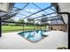 Screened-in pool area featuring a private backyard with mature landscaping and brick home at 104 Amberwood Ct, Longwood, FL 32779