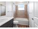 Bathroom has a white sink and vanity, bathtub with tiled walls and a window at 1091 Wood Dale Cir, Oviedo, FL 32765