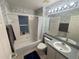 Cozy bathroom with vanity, tub with shower, patterned wallpaper, and natural light from the window at 11236 Rouse Run Cir, Orlando, FL 32817