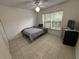 This bedroom features tile flooring, a ceiling fan, and a window with blinds for natural light at 11236 Rouse Run Cir, Orlando, FL 32817