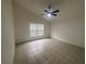 Spacious bedroom features tile flooring, a ceiling fan, and bright natural light from a window at 11236 Rouse Run Cir, Orlando, FL 32817