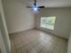 Bright bedroom features tile flooring and a ceiling fan, with a window offering natural light at 11236 Rouse Run Cir, Orlando, FL 32817