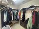 Walk-in closet with metal rack and shelves holding various clothes and personal items at 11236 Rouse Run Cir, Orlando, FL 32817