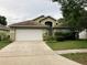 Charming home featuring an attached two-car garage, landscaped front yard, and welcoming front porch at 11236 Rouse Run Cir, Orlando, FL 32817