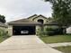 Charming home featuring an attached two-car garage, lush landscaping, and a welcoming entrance at 11236 Rouse Run Cir, Orlando, FL 32817