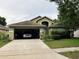 Charming home featuring an attached two-car garage, landscaped front yard, and welcoming front porch at 11236 Rouse Run Cir, Orlando, FL 32817