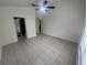 Spacious living room with neutral walls, tile flooring and ceiling fan; entryways to other rooms at 11236 Rouse Run Cir, Orlando, FL 32817