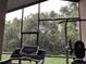 Enclosed patio with exercise equipment and views of the lush green outdoor area at 11236 Rouse Run Cir, Orlando, FL 32817