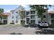 A view of the exterior of the white condo building featuring balconies, stairs, and parking spaces at 11588 Westwood Blvd # 1523, Orlando, FL 32821
